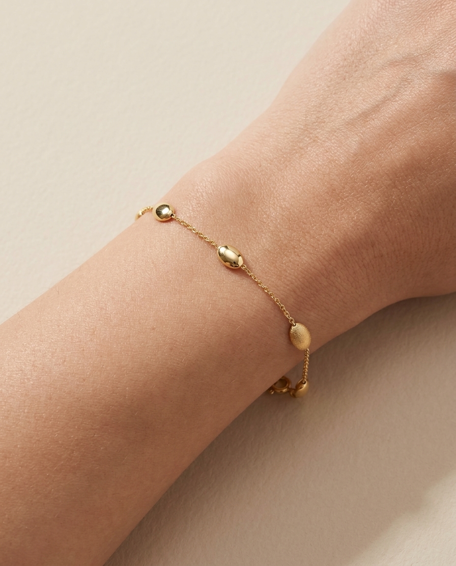 14KT Gold Bracelet with Oval Station Beads 7" on model